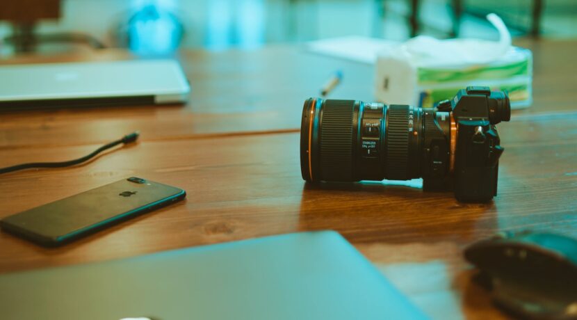 black iPhone 7 Plus and DSLR camera on table
