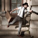 man in white dress shirt and gray pants sitting on gray concrete stairs