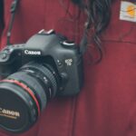 person wearing Canon DSLR camera