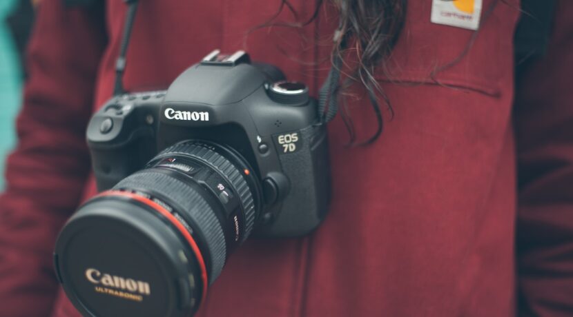 person wearing Canon DSLR camera
