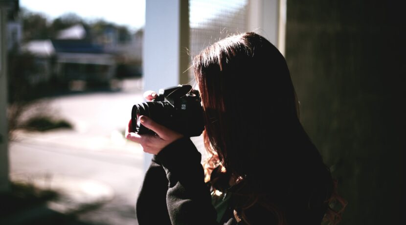 woman holding black DSLR camera