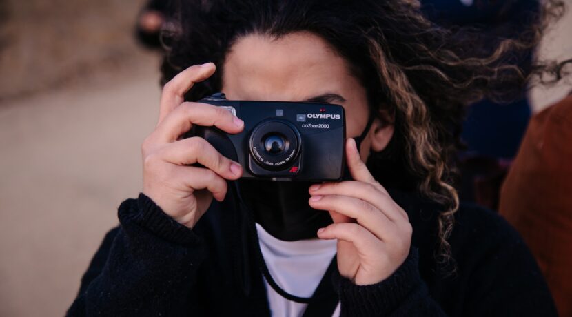 woman in black jacket holding black nikon camera