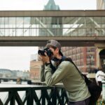 a man taking a picture of a bridge with a camera