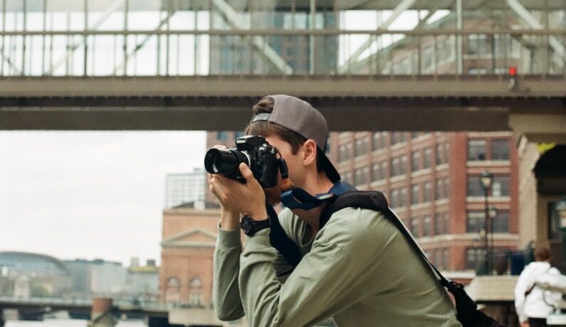 a man taking a picture of a bridge with a camera