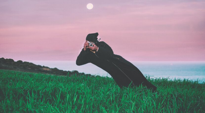 person talking photo in t he middle of grass field