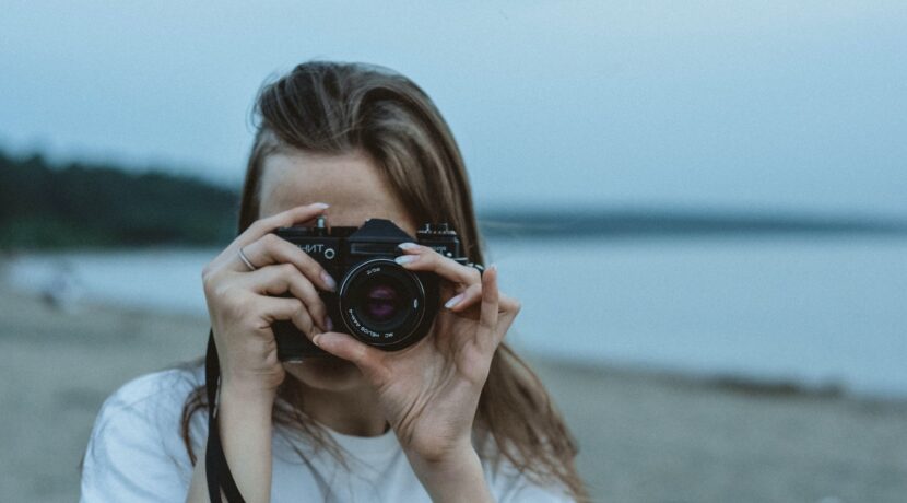 woman in white shirt holding black dslr camera