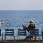 a group of people sitting on top of blue chairs