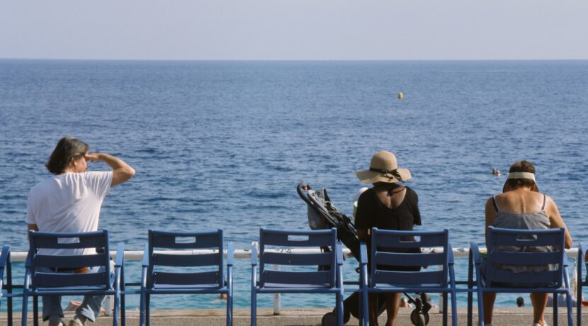 a group of people sitting on top of blue chairs