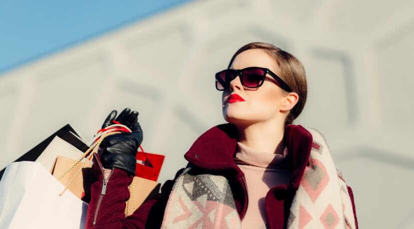 shallow focus photography of woman holding shopping bags during day
