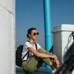 a woman sitting on the ground with a backpack