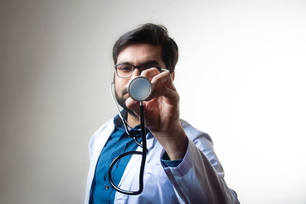 person in white shirt holding black and silver headphones