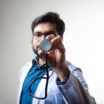 person in white shirt holding black and silver headphones
