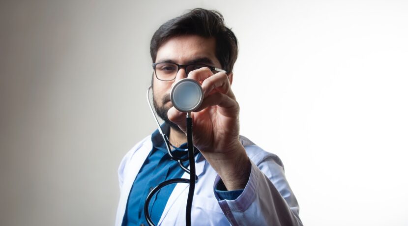 person in white shirt holding black and silver headphones