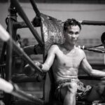 topless man in black and white shorts sitting on black metal frame