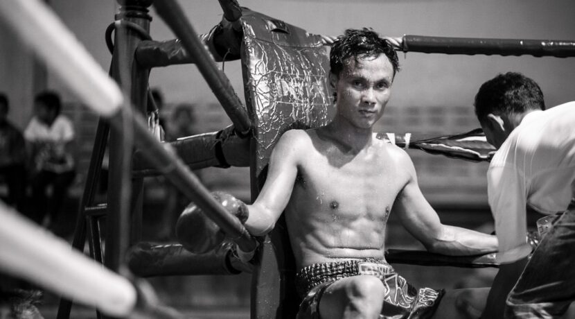 topless man in black and white shorts sitting on black metal frame