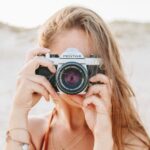 woman taking picture using silver Pentax camera