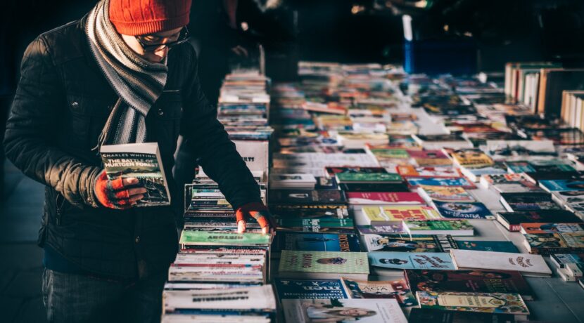 man picking up book ob book sale