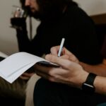 man writing beside man