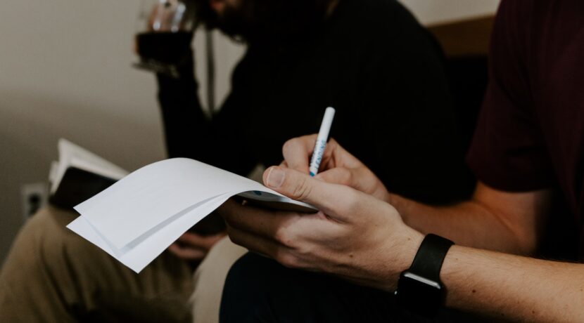 man writing beside man