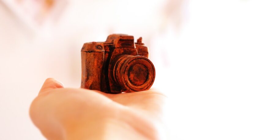 red camera scale model on human hand