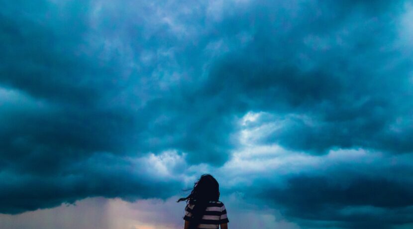 person wearing black and white stripe shirt across blue clouds