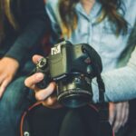 person carrying Canon DSLR camera