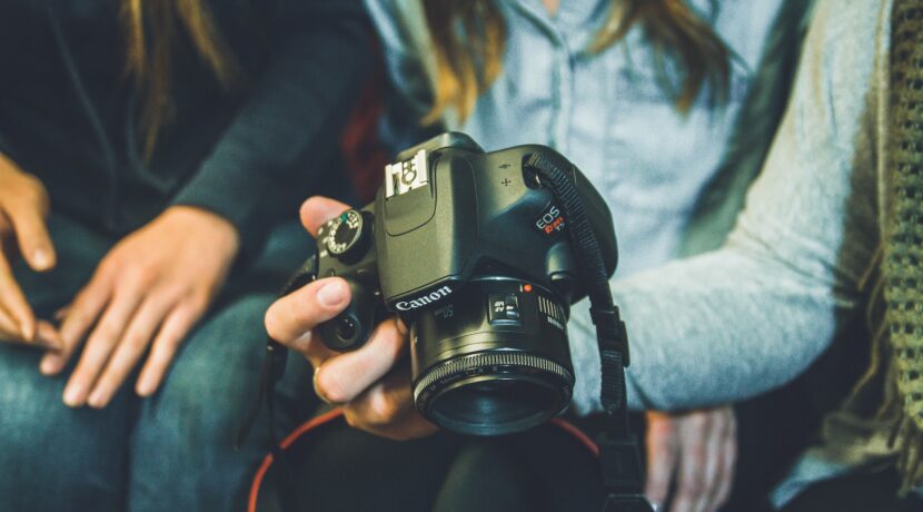 person carrying Canon DSLR camera