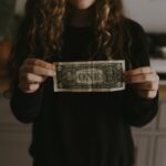 girl holding 1 U.S. dollar banknote
