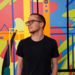 a man standing in front of a colorful wall