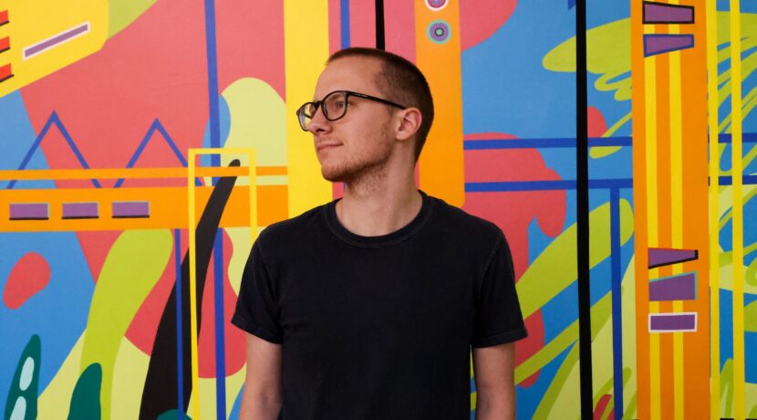 a man standing in front of a colorful wall