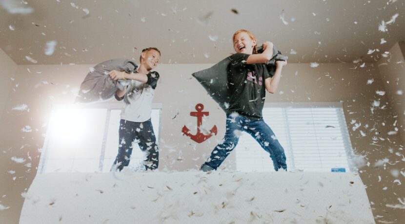 two toddler pillow fighting