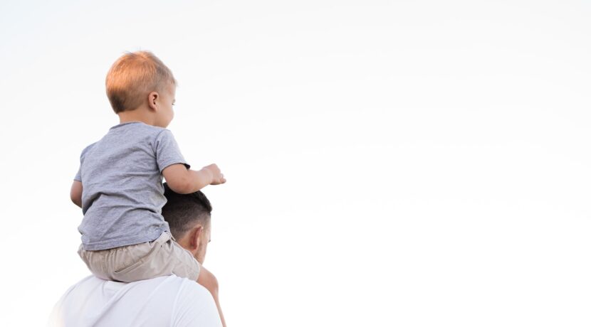 man in white shirt carrying boy