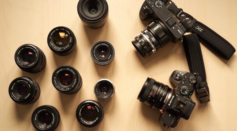 a group of cameras sitting on top of a wooden table