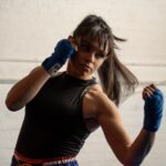 a woman in a black shirt and blue gloves