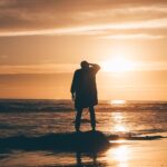 silhouette of person standing on body of water