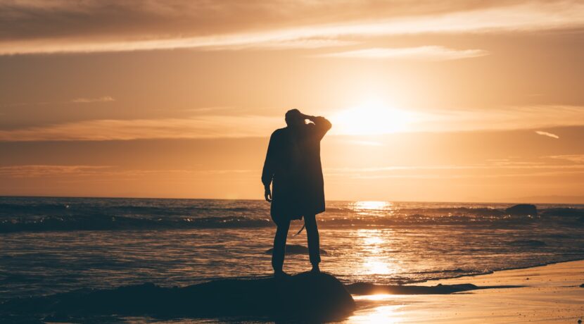 silhouette of person standing on body of water