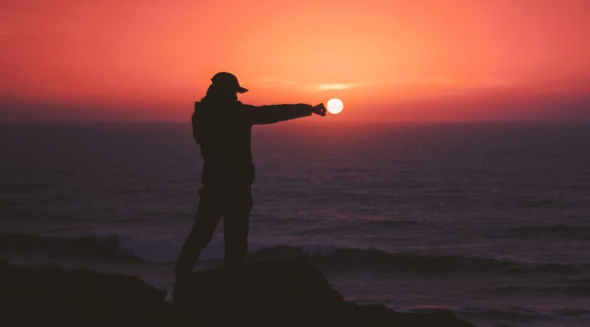 person standing on rock near body of water