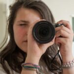 woman holding black camera taking photo