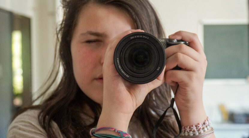 woman holding black camera taking photo