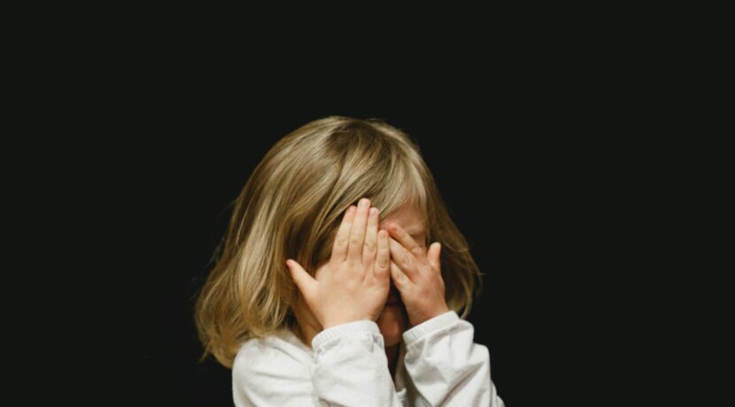 girl covering her face with both hands