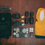 black dslr camera lens and yellow jacket on brown wooden table