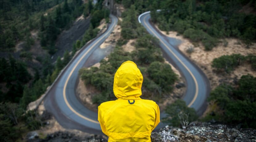 person in yellow coat standing on top of hill