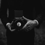 a black and white photo of a person holding a camera