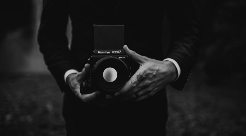 a black and white photo of a person holding a camera