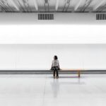a woman sitting on a bench in a large room
