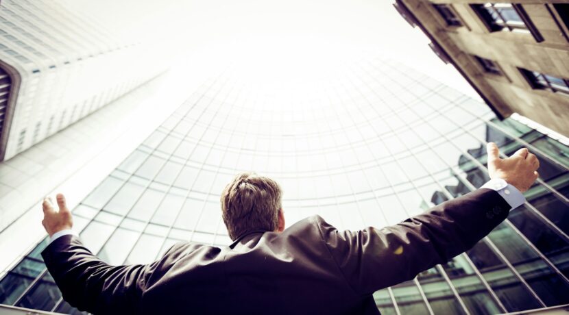 low-angle photography of man in the middle of buidligns