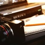 Sony compact camera near open spring notebook and pencil