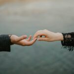 person in black long sleeve shirt holding hands with woman in black long sleeve shirt