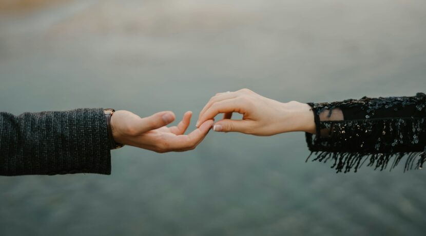 person in black long sleeve shirt holding hands with woman in black long sleeve shirt