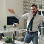 a man in a tie is dancing in an office